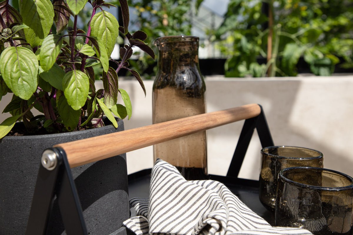 Table de jardin Moyo - une table d'appoint avec un plateau carré et une poignée en bois de teck